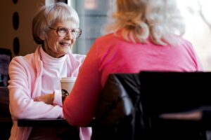 an elderly woman having a coffee